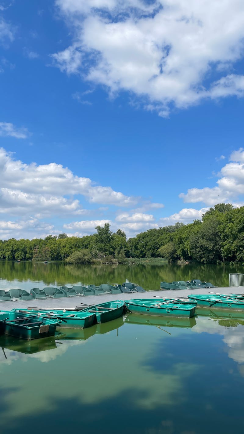 Lac pitoresc cu bărci sub cer albastru înnorat